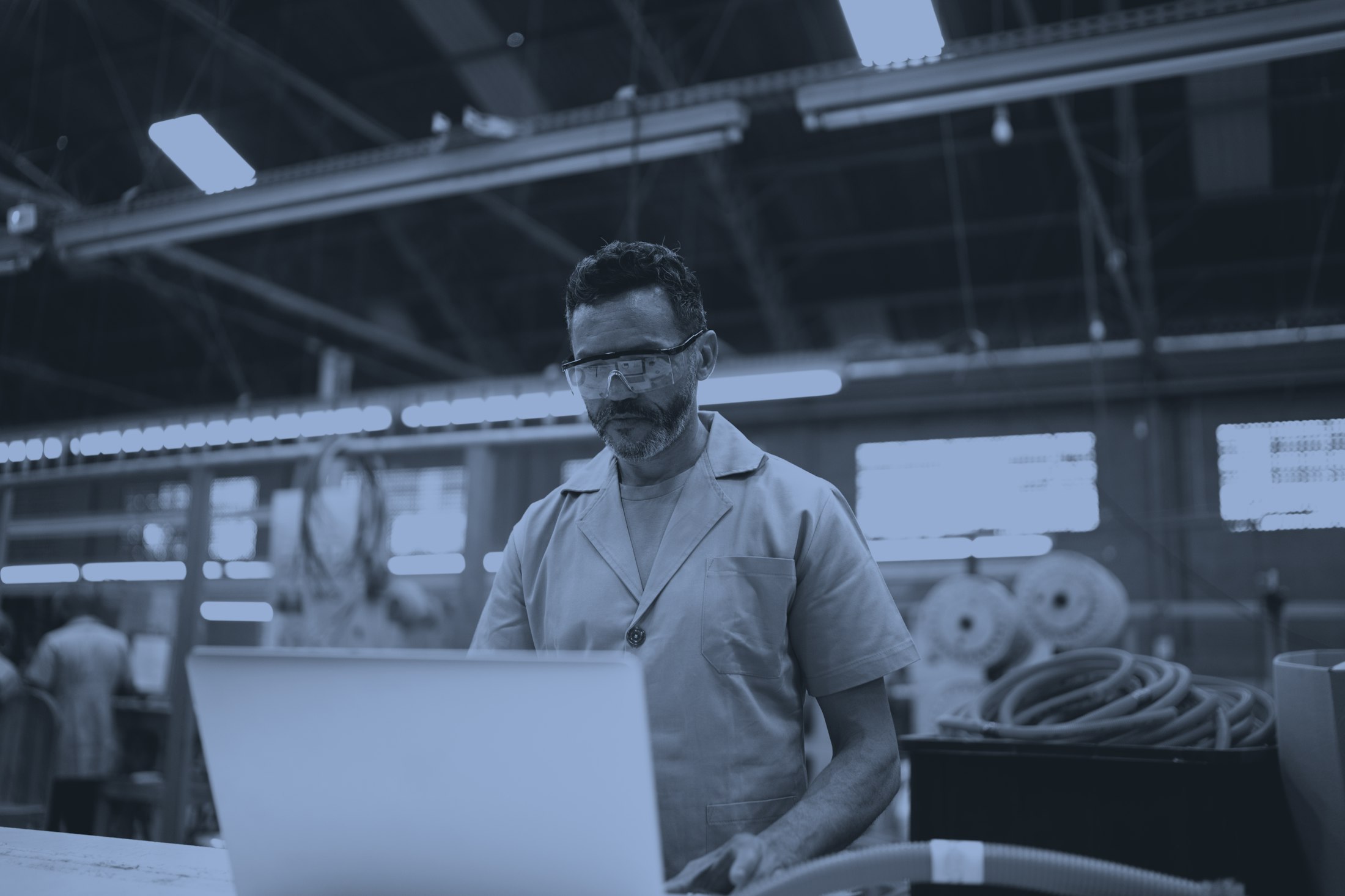 Technician on laptop in factory