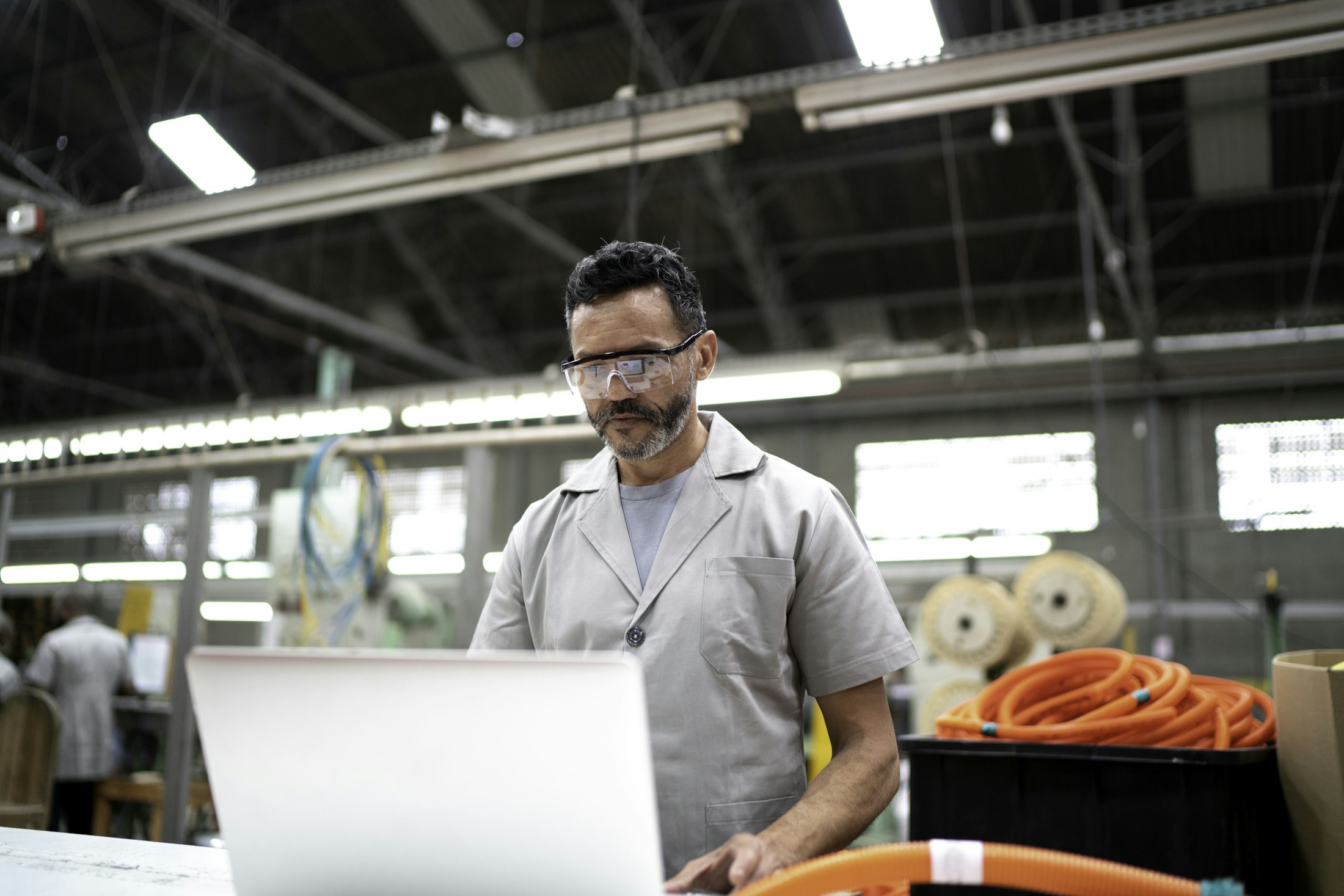 Technician on laptop in factory
